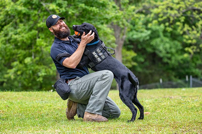 Man with dog jumping on his chest